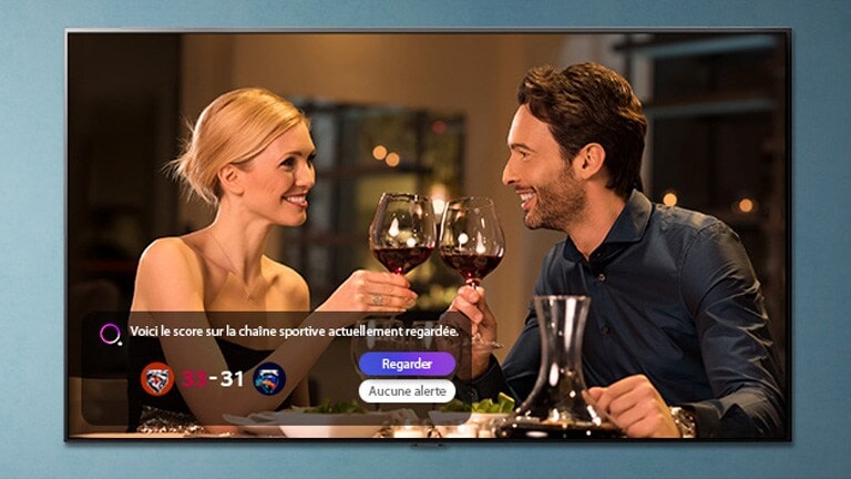 Un homme et une femme en train de trinquer sur un écran de téléviseur alors qu’une alerte sport s’affiche