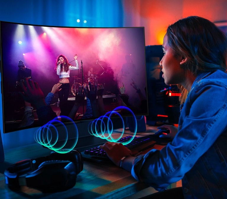 Image d’une personne regardant un concert sur un LG OLED Flex. Des bulles sonores décrivant les séquences audio sont émises à l’avant du téléviseur.