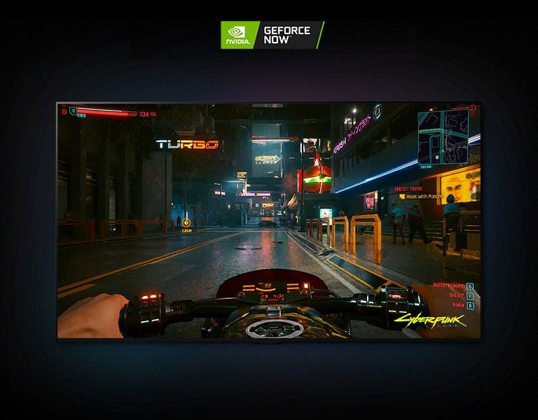 در یک صحنه Cyberpunk 2077 که از روی صفحه نمایش LG OLED پخش می شود ، این بازیکن یک موتورسیکلت را در یک خیابان نئون سوار می کند