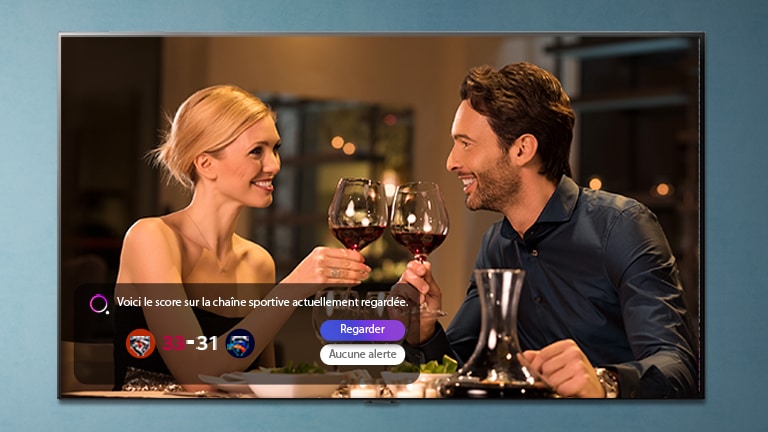 Un homme et une femme en train de trinquer sur un écran de téléviseur alors qu’une alerte sport s’affiche
