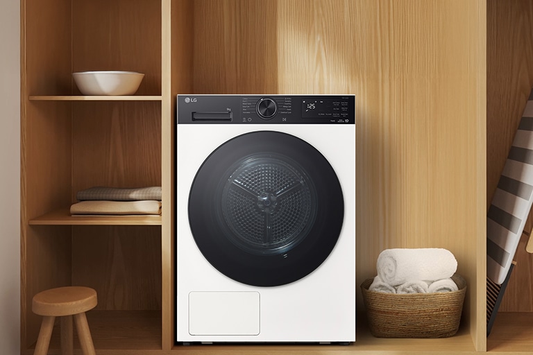 Image montrant la vue avant du sèche-linge LG dans un intérieur haut de gamme aux tons bois