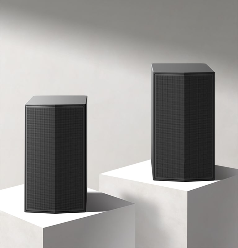 Les enceintes arrières sur un podium en marbre dans un espace blanc. 