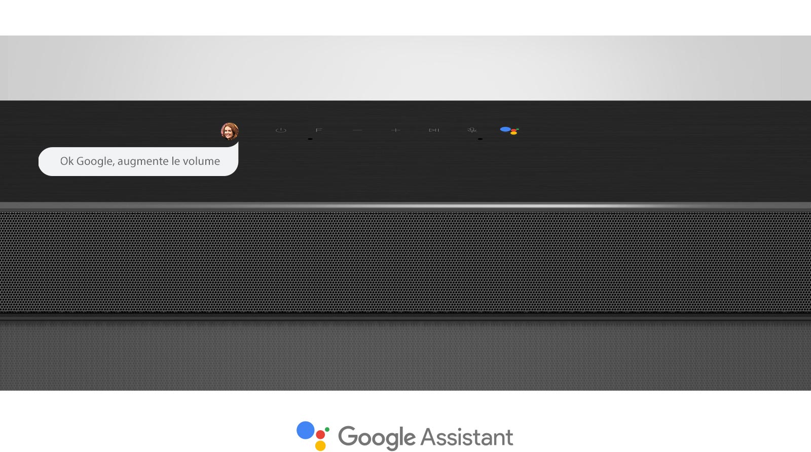 Gros plan de la barre de son LG en section centrale avec les commandes audio et le logo Assistant Google. Avec la commande vocale de Google pour augmenter le volume. 