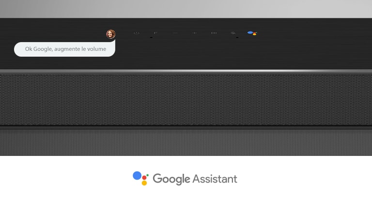Gros plan de la barre de son LG en section centrale avec les commandes audio et le logo Assistant Google. Avec la commande vocale de Google pour augmenter le volume. 