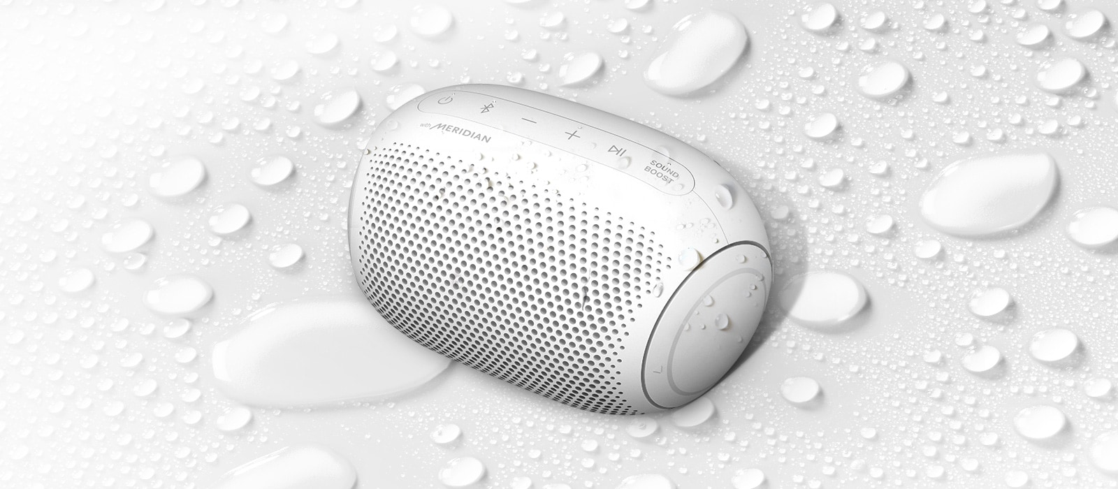 Sur un fond blanc, le LG XBOOM Go est orienté vers la gauche. Il y a des gouttelettes d’eau sur le LG XBOOM Go et en dessous de celui-ci.