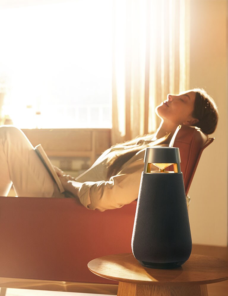 Une femme écoute de la musique assise sur un canapé.