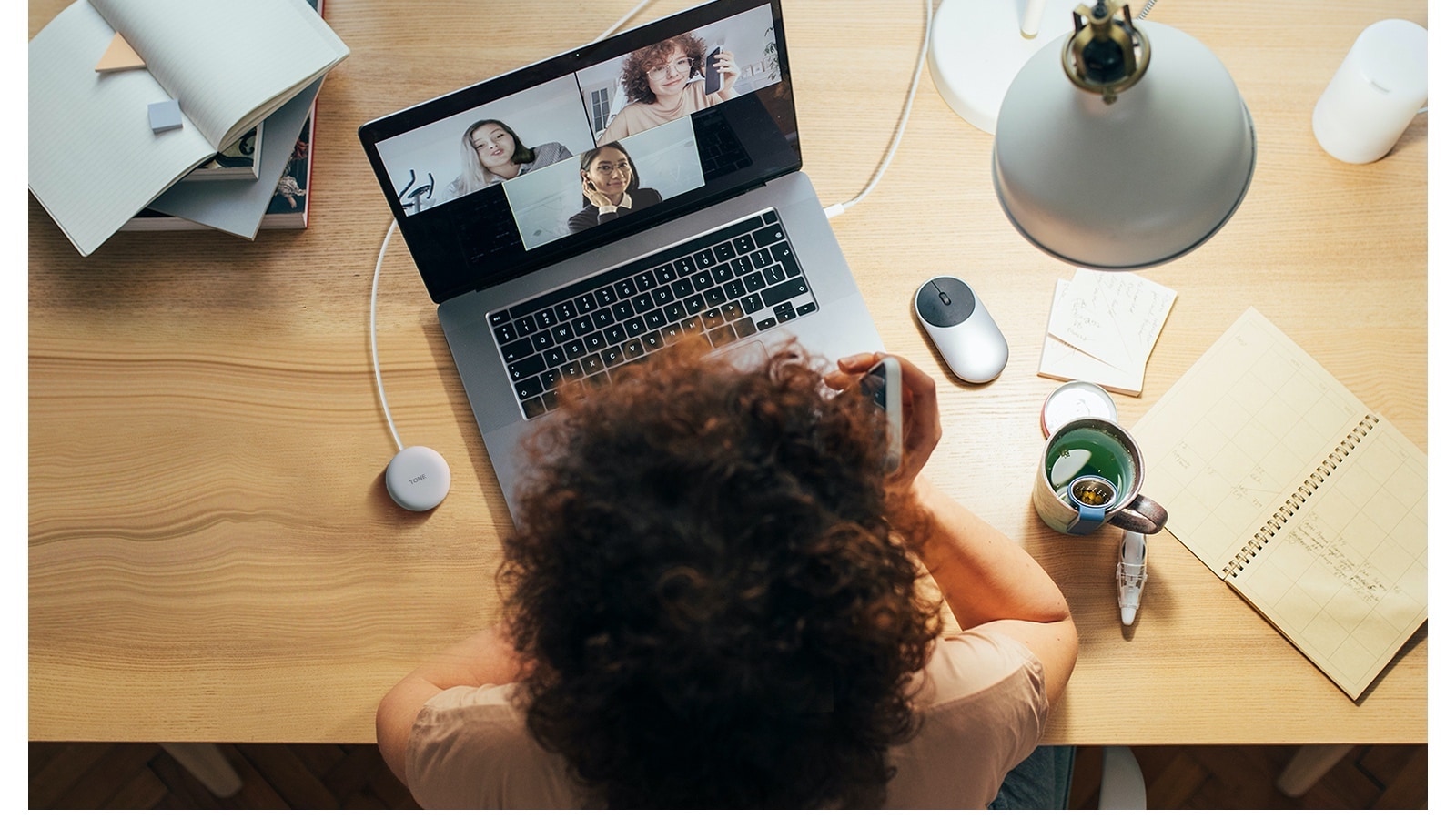 Une femme travaille sur un ordinateur et utilise la connexion sans fil pour participer à une conférence téléphonique.