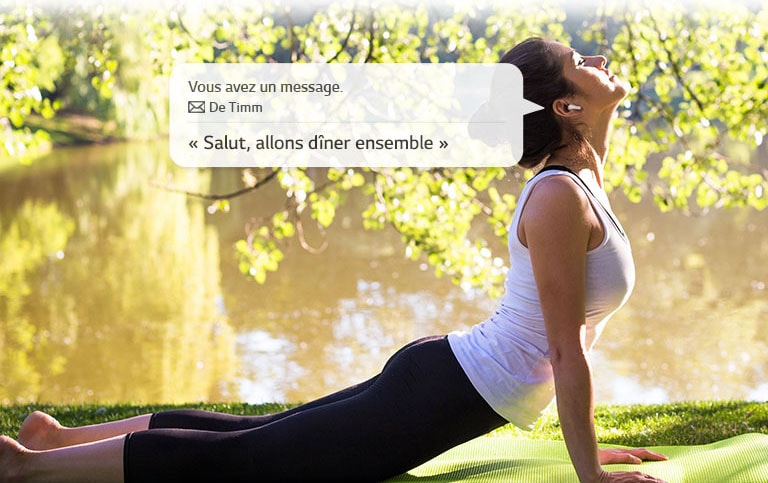 Une femme s'étire et se penche pour toucher le sol tout en écoutant un message que ses oreillettes lisent pour elle.