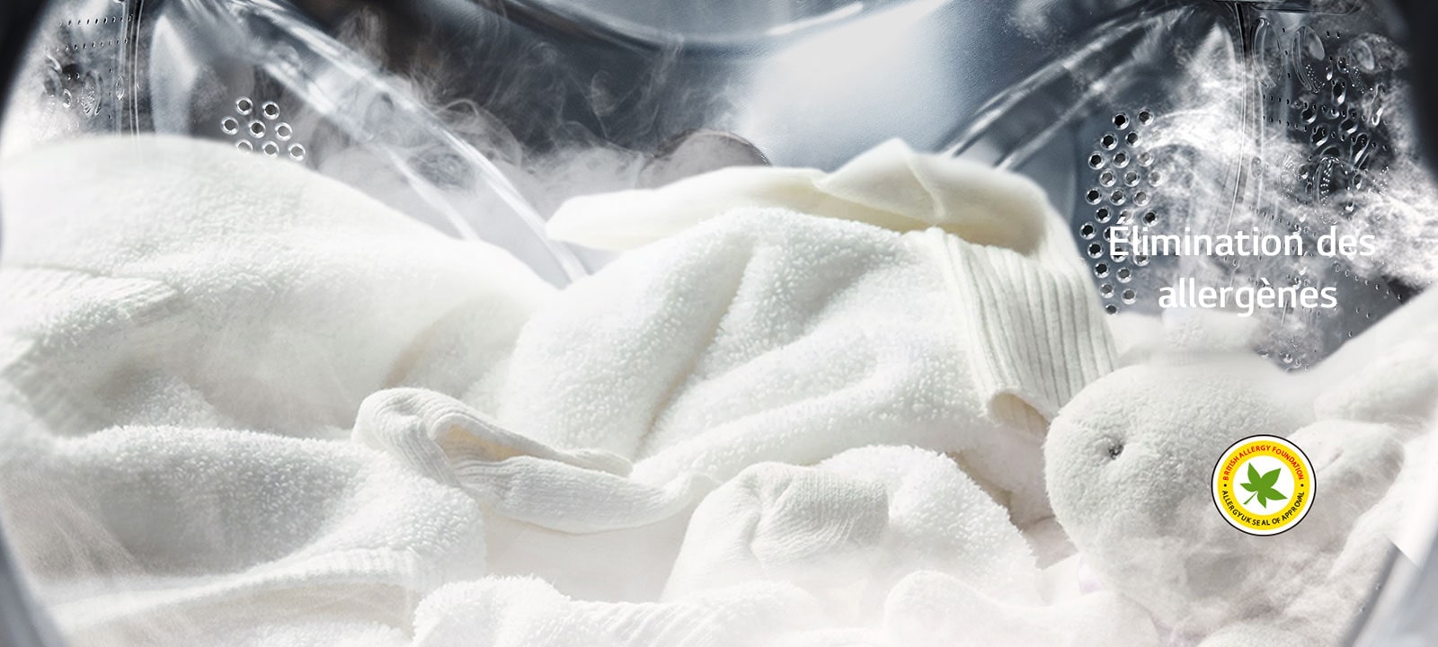 Un peignoir blanc et un animal en peluche sont présentés avec de la vapeur dans le tambour de la machine à laver.