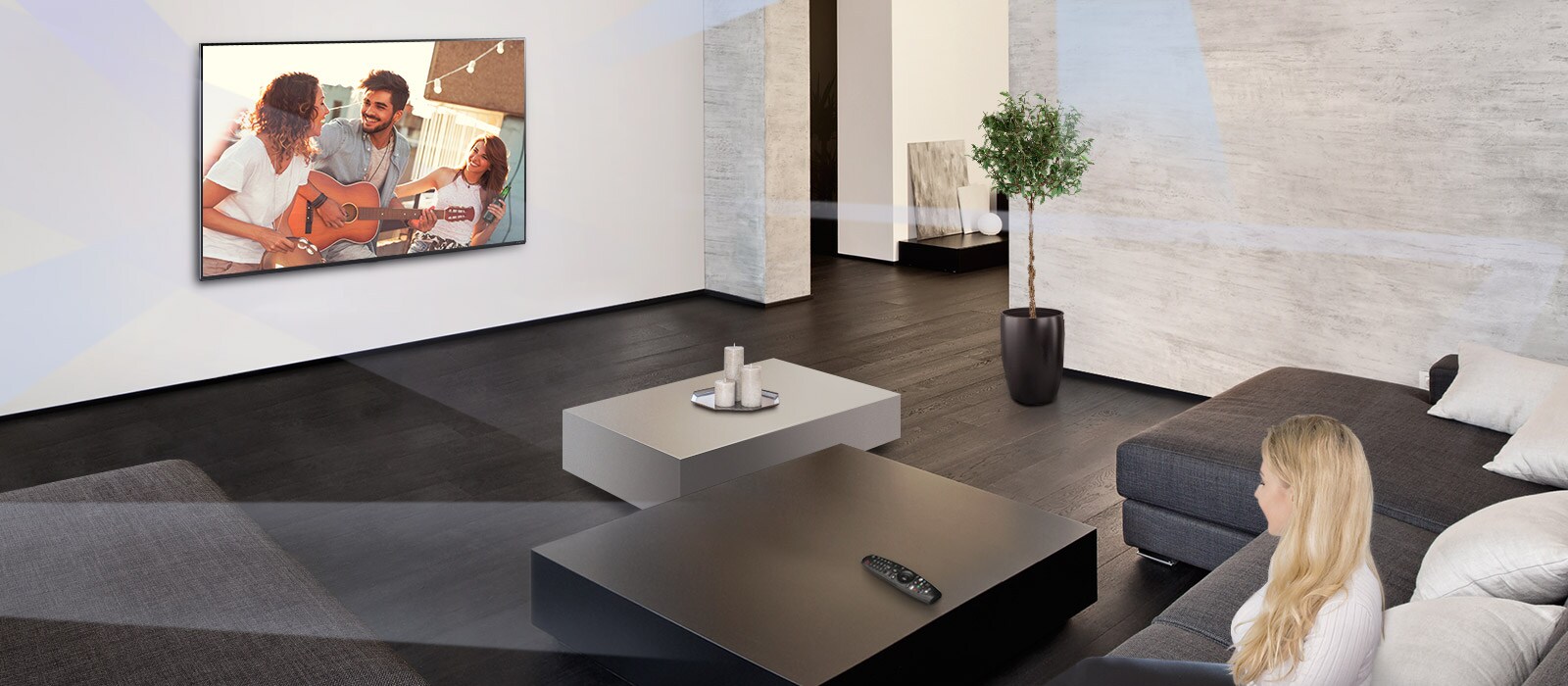 Une femme dans un grand salon à la décoration minimaliste en train de regarder des gens jouer sur un téléviseur