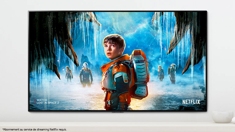 Une scène de la deuxième saison de Perdus dans l’espace sur l’écran du téléviseur où les personnages principaux observent le ciel avec un regard intense.