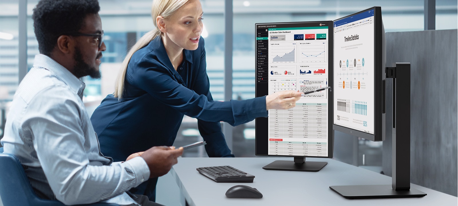 Deux hommes et une femme se parlent tout en regardant un moniteur dans un bureau.