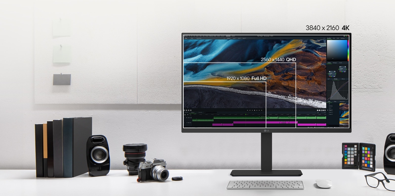 Vue avant d’un moniteur LG noir sur un bureau affichant des résolutions d’écran superposées pour permettre une comparaison, entouré d’appareils photos, de livres, d’échantillons de couleurs et de haut-parleurs.