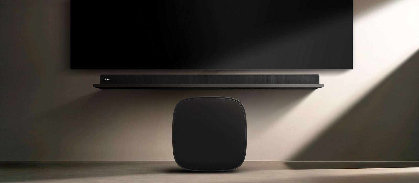 Le caisson de basses LG Sound Suite W7 placé sous une TV avec une barre de son, affichant une expansion sonore sans fil facile pour un système audio stéréo domestique immersif
