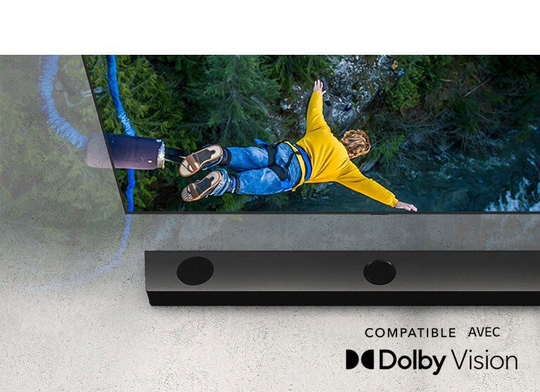 Le téléviseur LG montre une personne qui saute à l’élastique et la barre de son LG est placée sous le téléviseur.