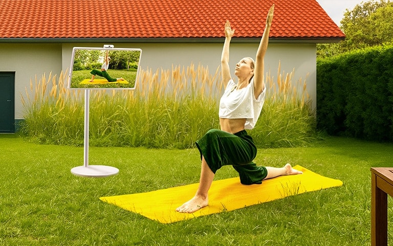 A woman in a yoga pose reflected on the screen of StanbyME 2.
