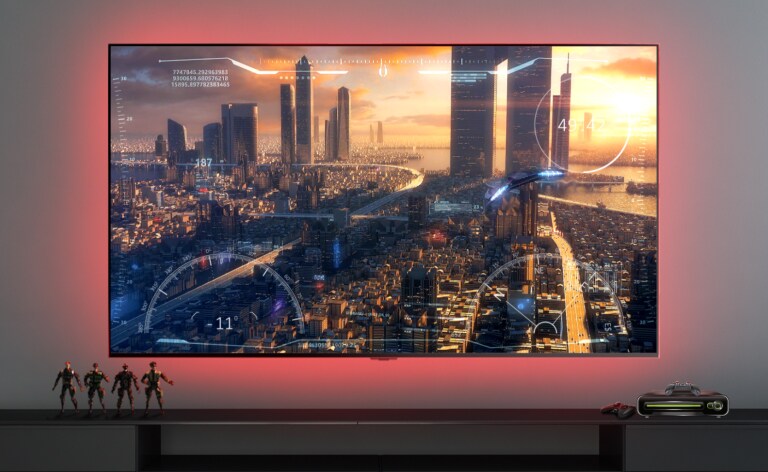 Scène d’un jeu vidéo montrant un vaisseau spatial survolant une ville, présentée sur un écran de télévision (lire la vidéo).