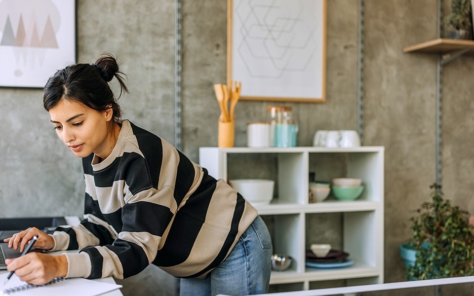 Une femme mesure sa cuisine pour trouver les bonnes dimensions de réfrigérateur