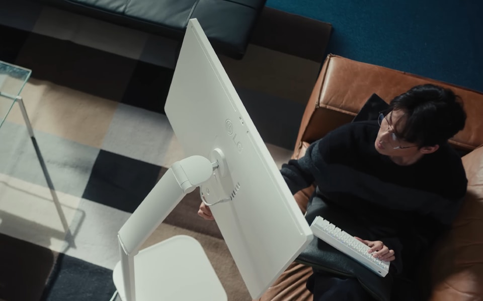 A man working while looking at an LG 360 monitor.