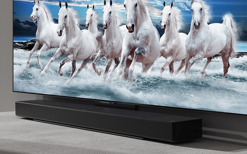 Une barre de son Bluetooth fine s'associe parfaitement à un téléviseur LG affichant une image de chevaux blancs.