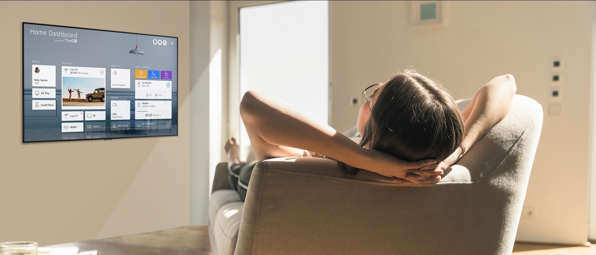 Une femme sur un canapé demandant au téléviseur de baisser la température avec l’écran d’accueil sur l’écran du téléviseur