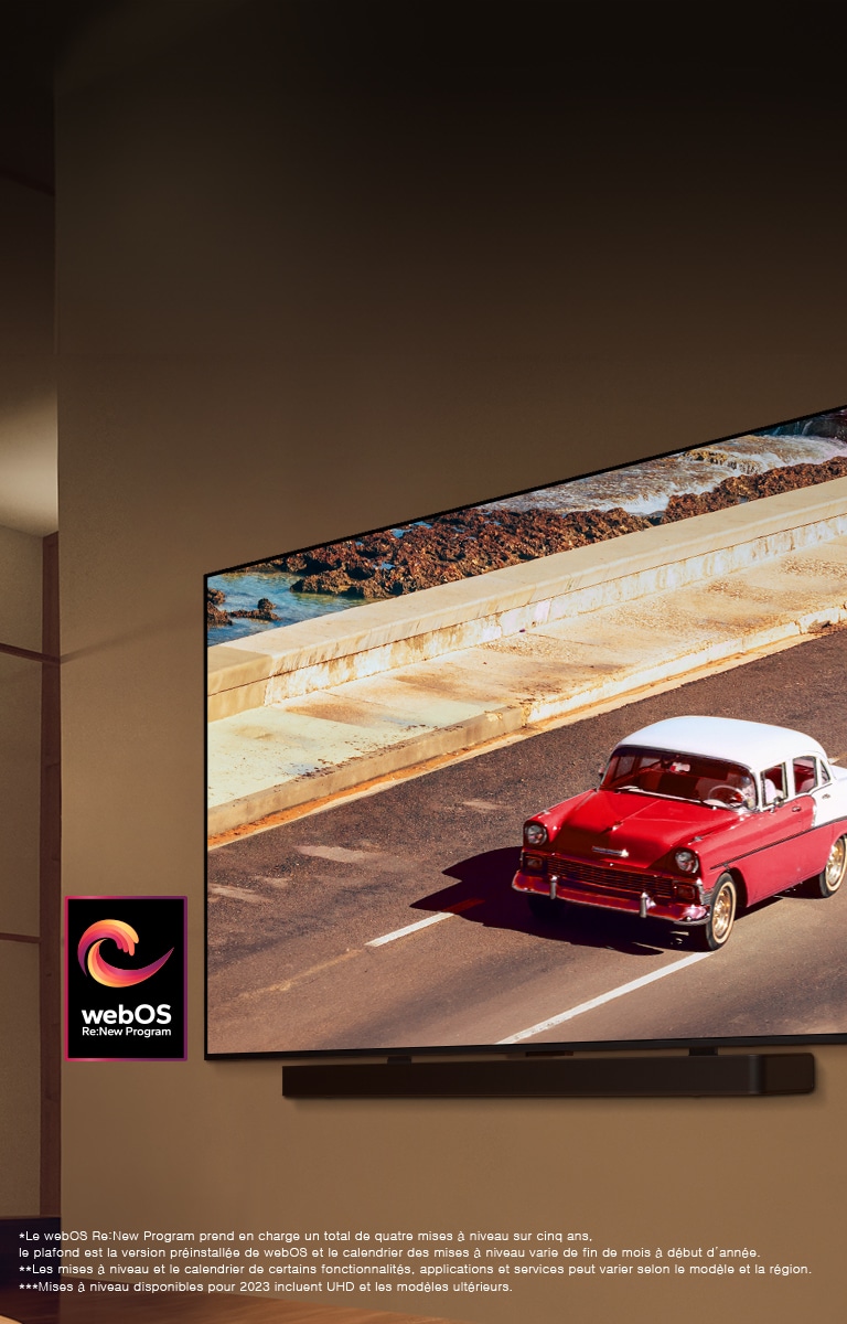 LG QNED TV et Soundbar sont montés sur un mur dans une pièce éclairée par une lumière tamisée. La TV affiche un véhicule rouge sur une route. Le logo du programme webOS Re:New est sur l’image. Une notice indique : « Le webOS Re:New Program prend en charge un total de quatre mises à niveau sur cinq ans, le plafond est la version préinstallée de webOS et le calendrier des mises à niveau varie de fin de mois à début d’année. » « Les mises à niveau et le calendrier de certains fonctionnalités, applications et services peut varier selon le modèle et la région. »