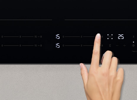 Снимка показваща докосване на панела за управление на индукционния плот.