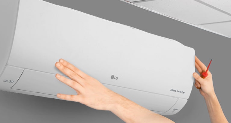 На стената се вижда страничният изглед на климатика. Две ръце се протягат нагоре, като едната държи инструмент, показвайки лекотата на монтажа.