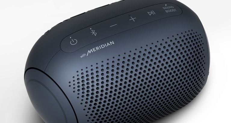 Изглед в близък план на логото на Meridian върху LG XBOOM Go на бял фон с осветление в пурпурно.