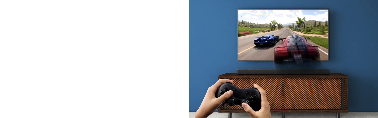 На стена има окачен телевизор LG, на който се вижда състезателна игра. Саундбар LG е поставен на кафяв рафт, точно под телевизора LG. Мъж държи джойстик. В горния ляв ъгъл е показано обозначението НОВО.