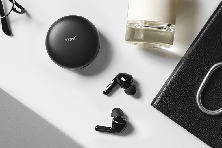 Изображение на пет кутийки на LG TONE Free Fn6 в пет различно оцветени калъфа, носещи се към бляскав под