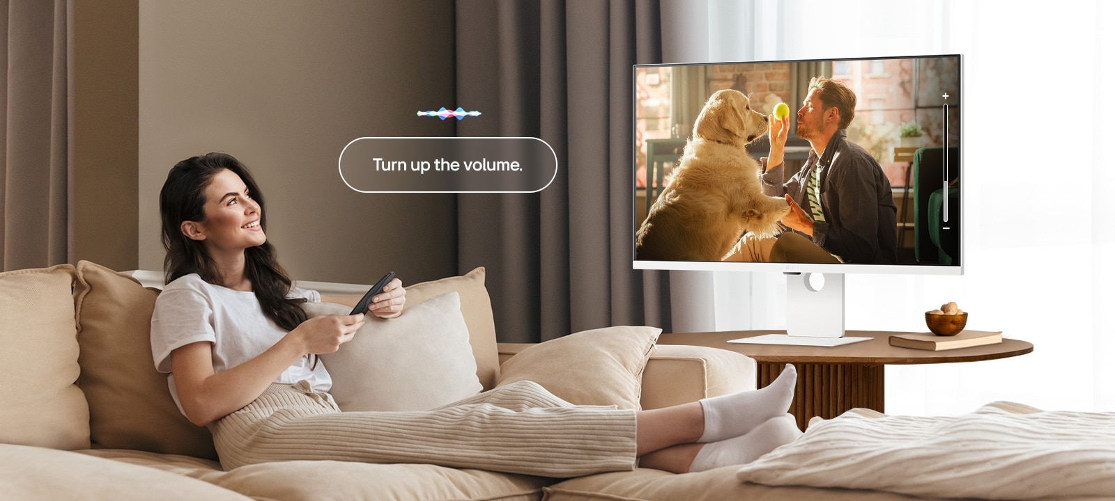 Една жена увеличава силата на звука на LG Smart Monitor с помощта на дистанционното управление Magic Remote.