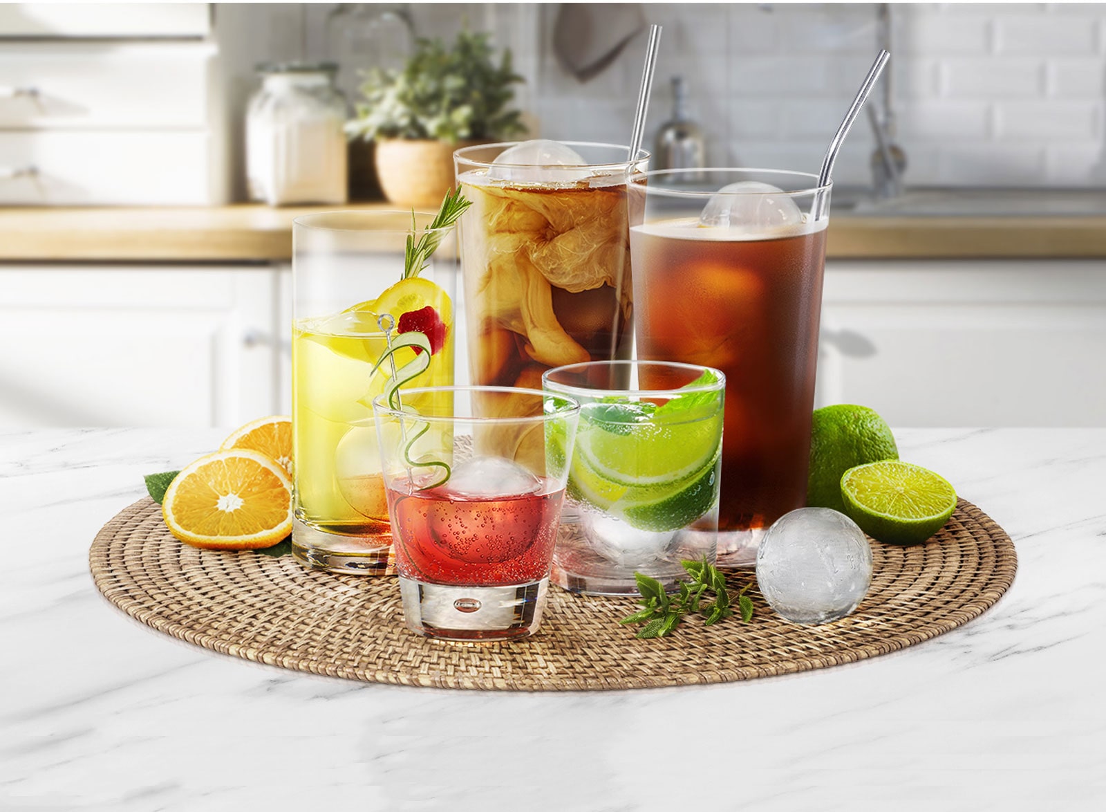 На кухненски плот има различни чаши с различни размери, в които се държат различни напитки с кръгли кубчета лед.