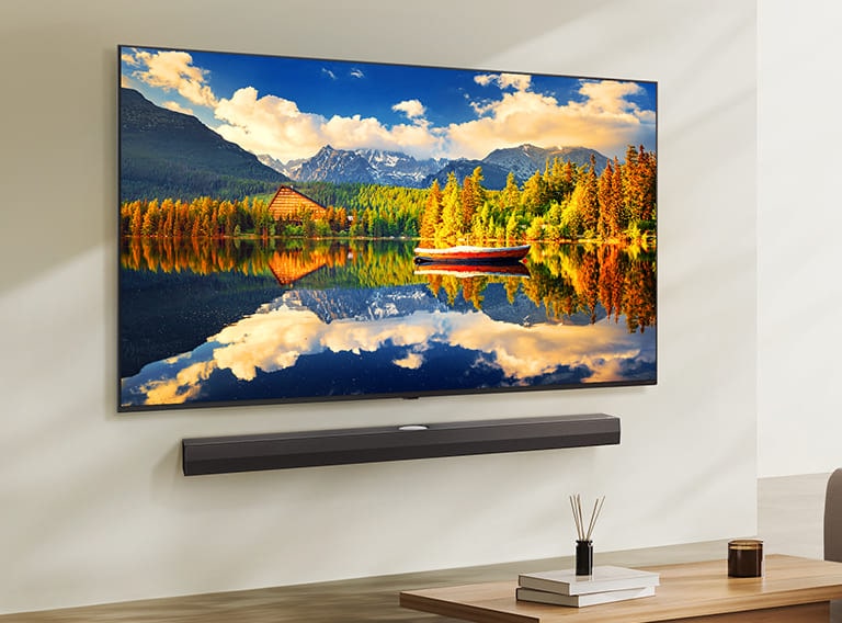 LG NanoCell телевизор, монтиран на стена над LG саундбар в съвременна всекидневна. LG NanoCell телевизор показва цветен фон.