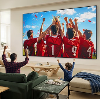 LG QNED evo AI QNED85 Mini LED Ultra Big TV е монтиран на стената в хола и излъчва празненствата по повод спортна победа.
