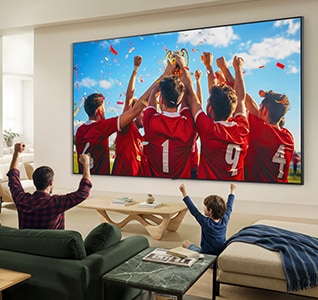 LG QNED evo AI QNED85 Mini LED Ultra Big TV е монтиран на стената в хола и излъчва празненствата по повод спортна победа.
