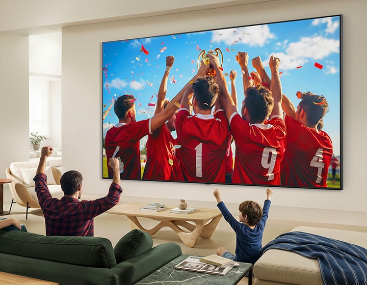 LG QNED evo AI QNED85 Mini LED Ultra Big TV е монтиран на стената в хола и излъчва празненствата по повод спортна победа.