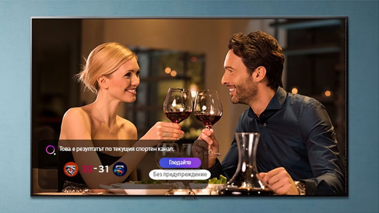 Мъж и жена вдигат наздравица на телевизионния екран, докато се показват известия за спортни събития