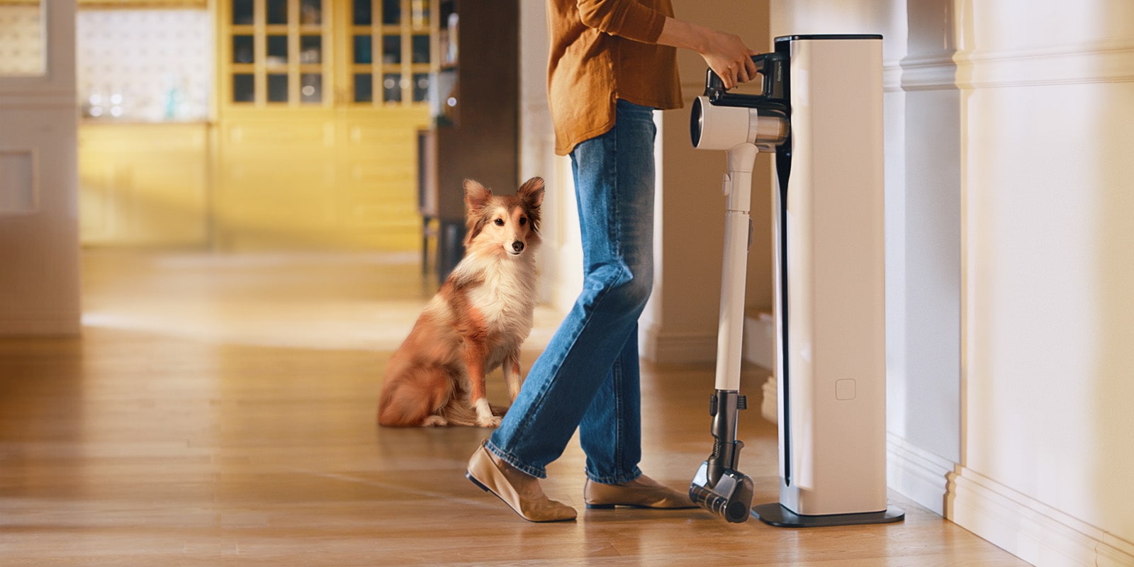 A woman is putting in a Cordzero™ Vacuum cleaner in a docking station.
