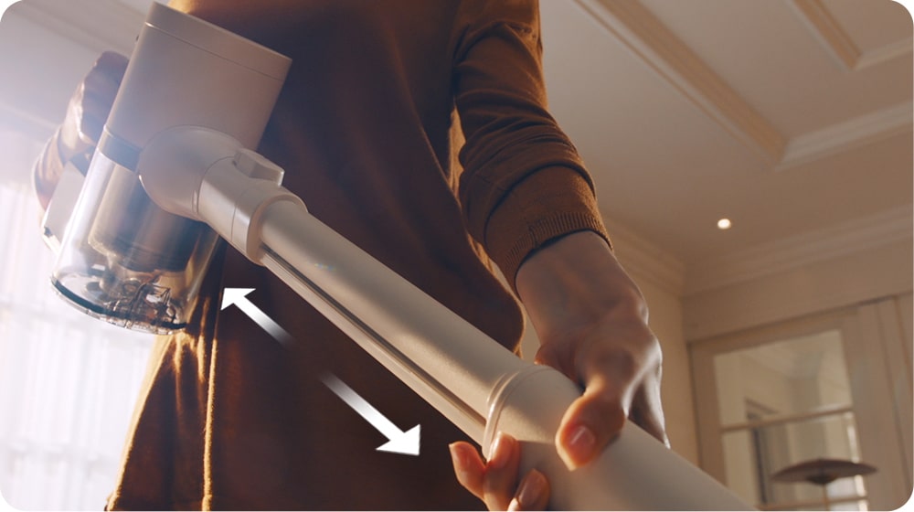A woman is shown adjusting the handle of the Cordzero™ vacuum cleaner.