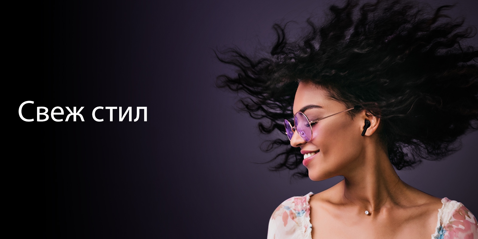 Жена се усмихва, докато слуша музика с TONE Free.