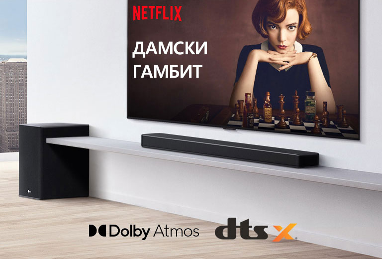 Телевизорът е на стената.  На телевизионния екран се показва постер на телевизионен сериал. Саундбарът LG е поставен точно под телевизор на бял рафт със субуфер в съседство. Логото Dolby Atmos и DTS:X е показано в средата на долната част на изображението.
