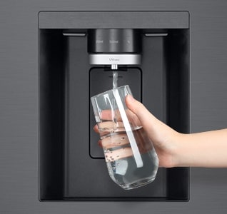 Човек си налива чаша вода от диспенсера за вода на хладилника LG Multi-door.