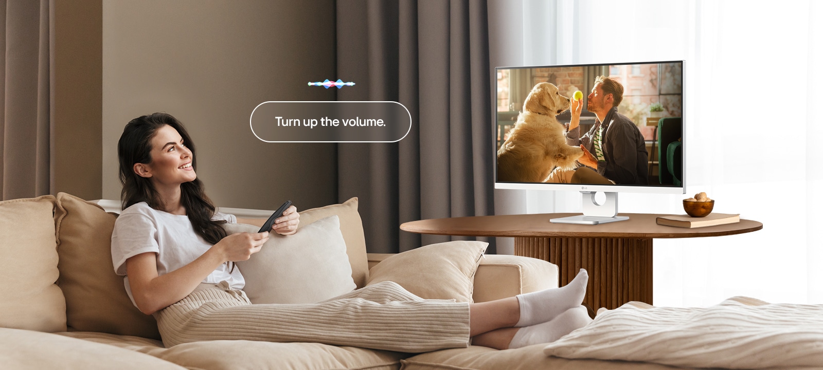 Една жена увеличава силата на звука на LG Smart Monitor с помощта на дистанционното управление Magic Remote.	