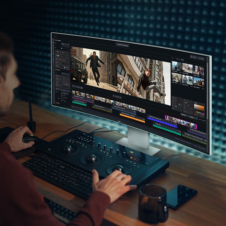 Човек работи с програма за създаване на видео на монитор UltraFine.