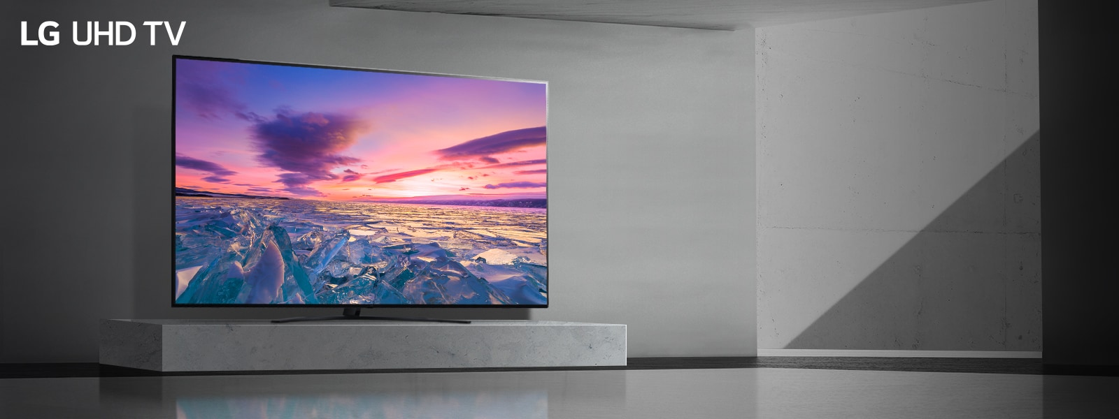 Телевизор в празна стая показва на екрана ярък залез с наситени цветове.