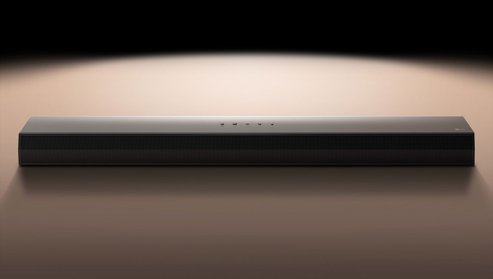 Картина на LG саундбар на черен фон, осветен от прожектор. 