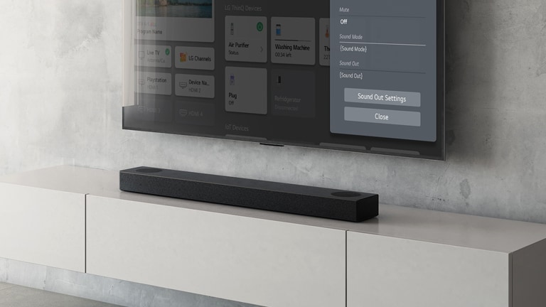 На стената е окачен телевизор LG, показващ екран за настройка на саундбара. Намиращият се под него саундбар S75Q на LG е поставен на рафт. В горния ляв ъгъл е показано обозначението НОВО.