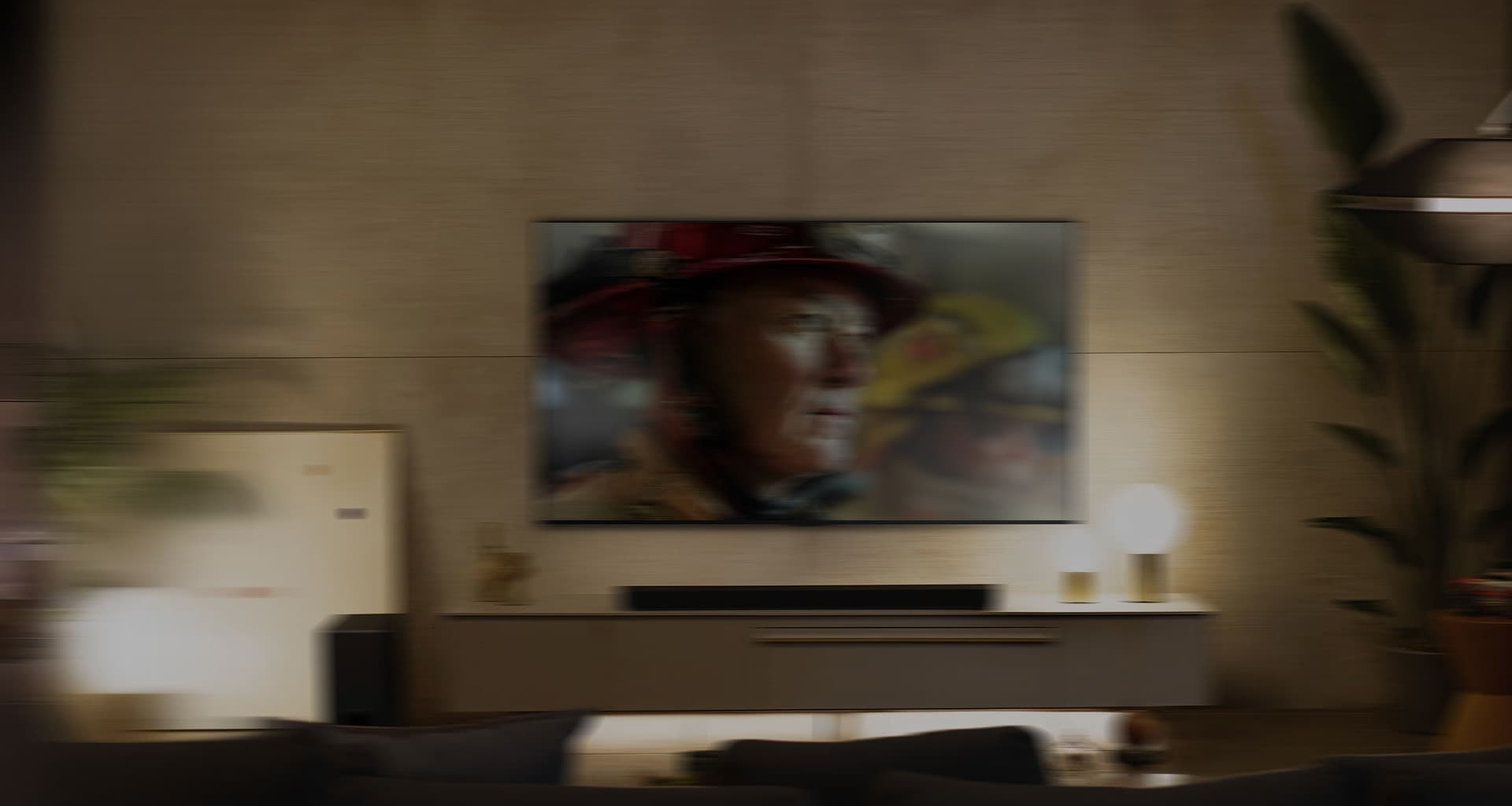 LG OLED телевизор е в уютна всекидневна стая през нощта. Докато филмът се възпроизвежда, се появяват мехурчета, изобразяващи съраунд.