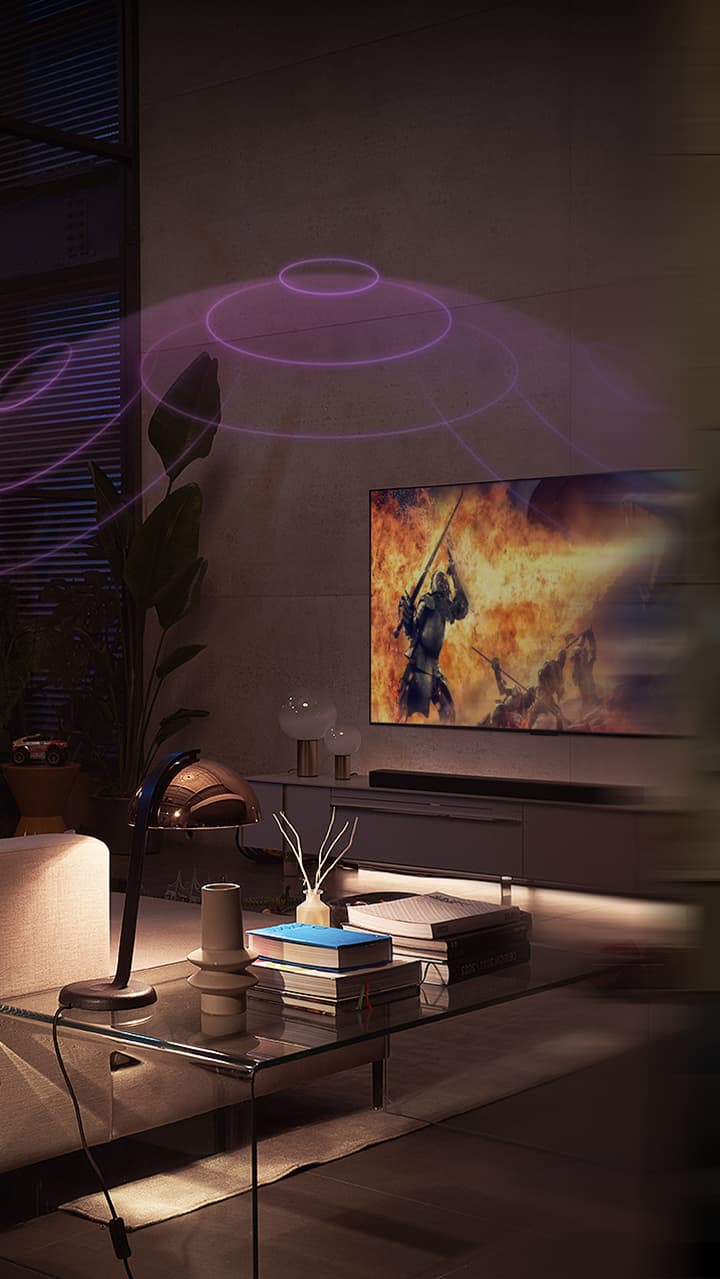 LG OLED телевизор е в уютна всекидневна стая през нощта. Докато филмът се възпроизвежда, се появяват мехурчета, изобразяващи съраунд.